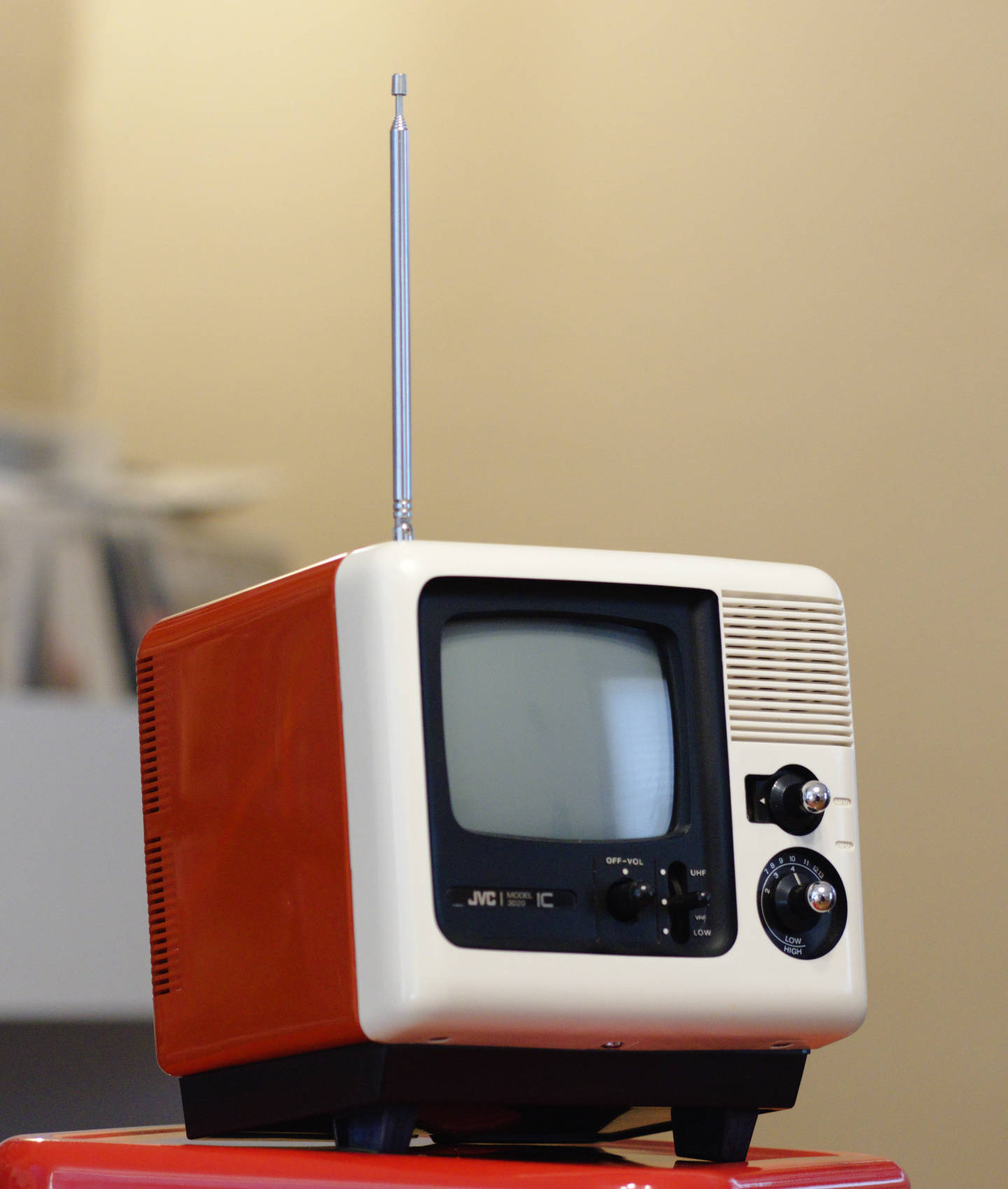 Color photo of the JVC 3020 IC television set, a small portable tv from the early 1970s. It is made of shiny red and white plastic with details in matte black and chrome.