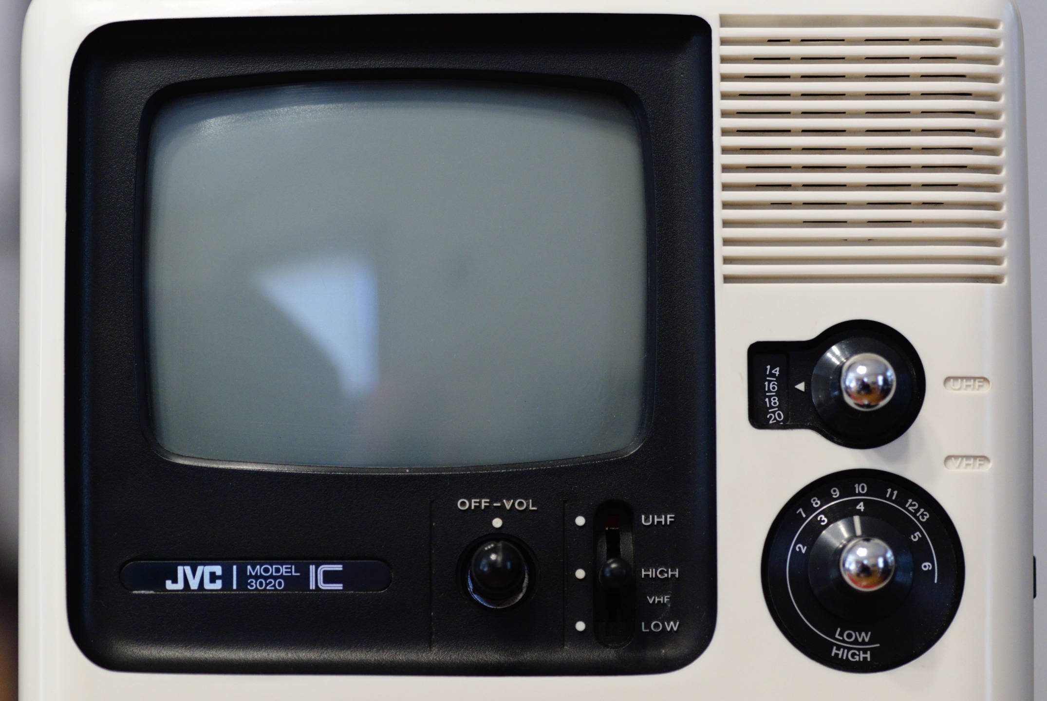 Color photo, detailed view of the front of the JVC 3020 IC television set showing its frame of black and white plastic, the small 5 inch screen, and its controls.