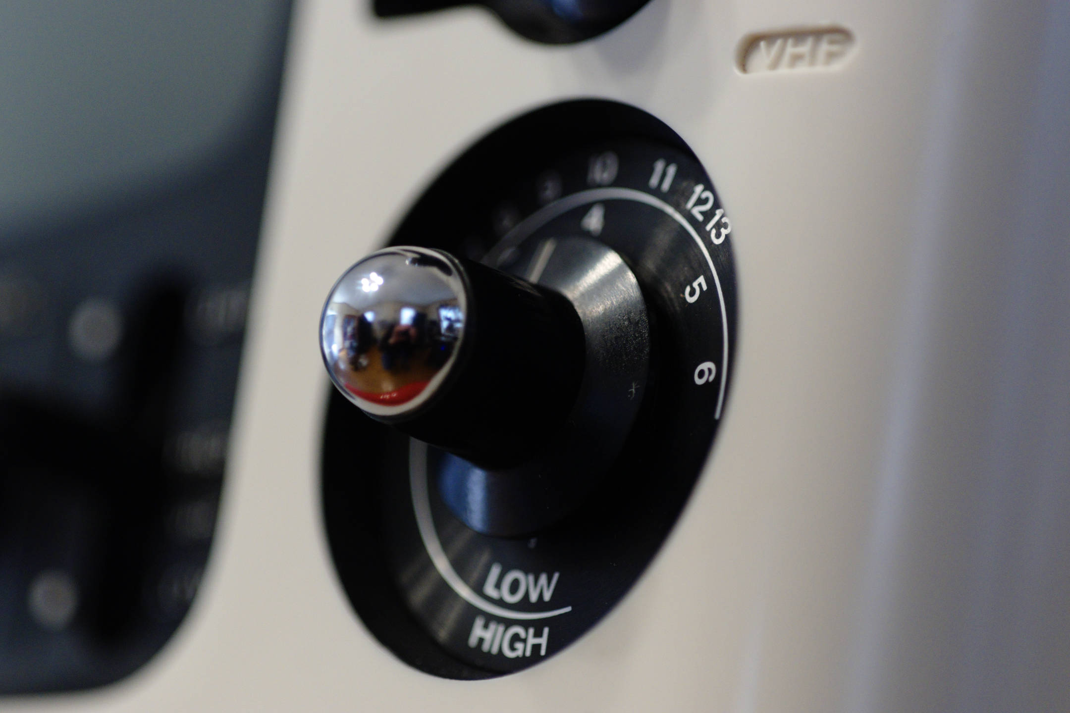 Color photo, detailed view of the black and chrome VHF channel knob of the JVC 3020 IC television set.