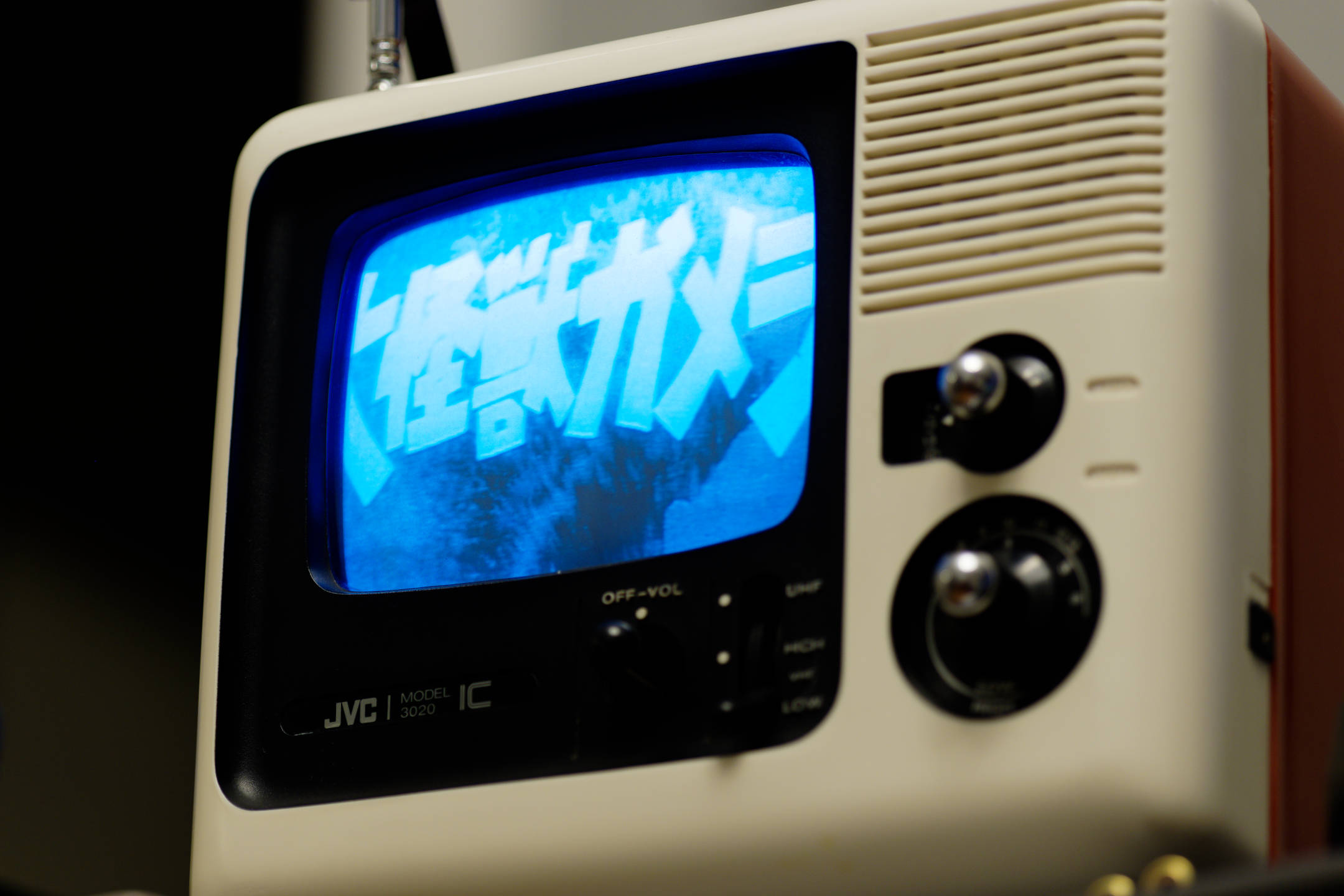 Color photo of the JVC 3020 IC television viewed from a low angle, with the opening title shot of the 1965 film Giant Monster Gamera showing on its small black and white screen.